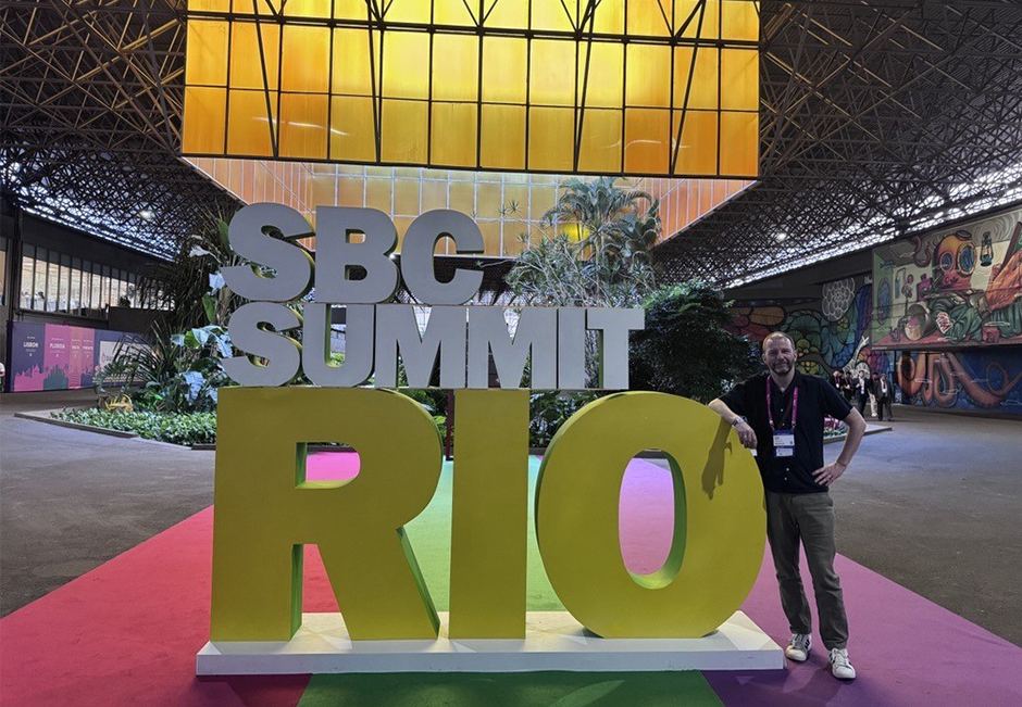 Attendee at SBC Summit Rio 2026 standing next to the event signage at RioCentro