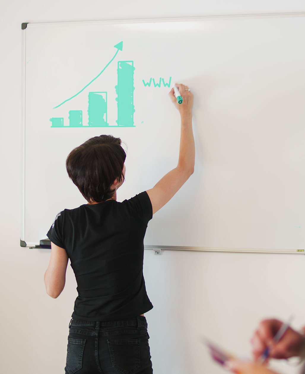 An employee drawing an innovative strategy on a whiteboard.