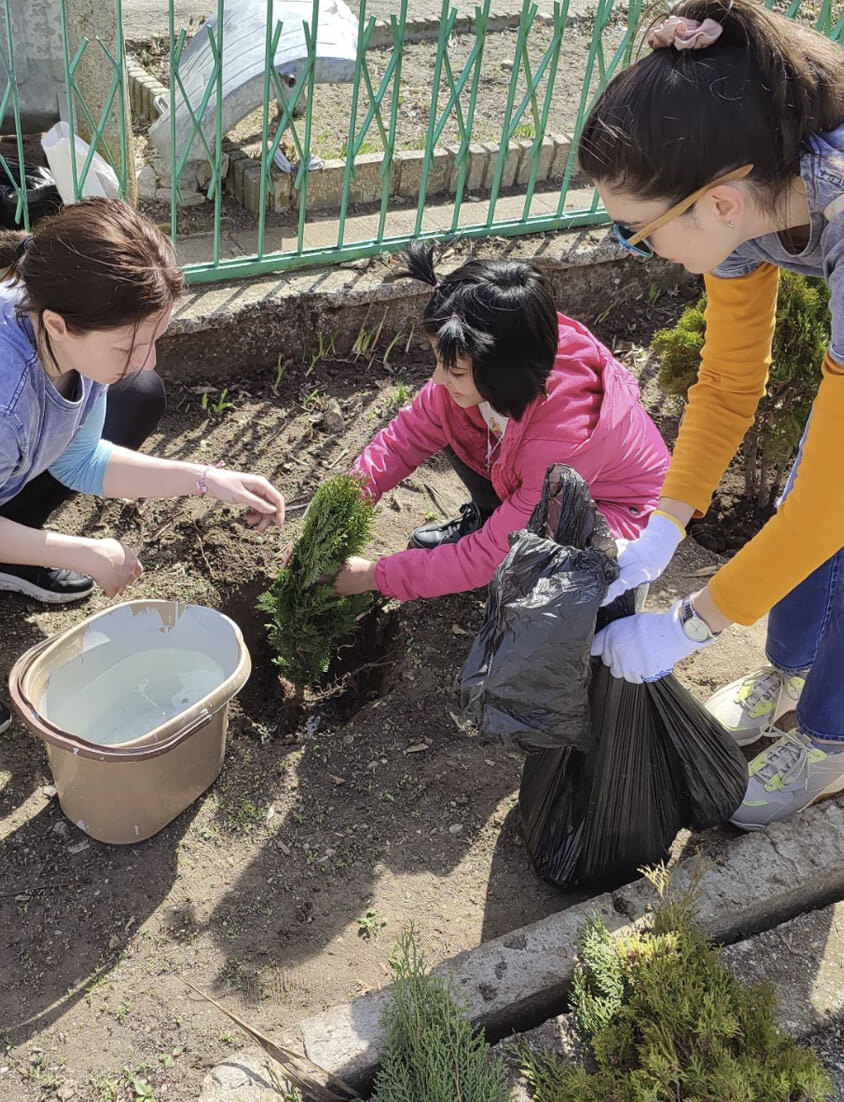 iGaming.com Employee and Children Planting a Tree at a Community Event