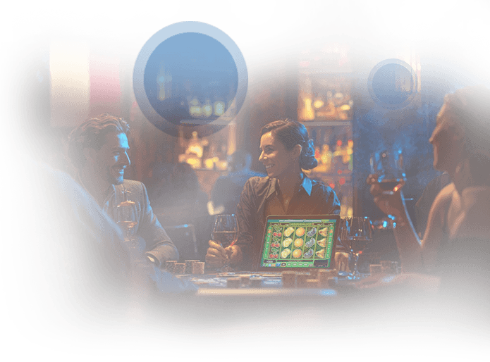 Tavolo da gioco, persone sedute che prendono un drink e PC portatile con slot online